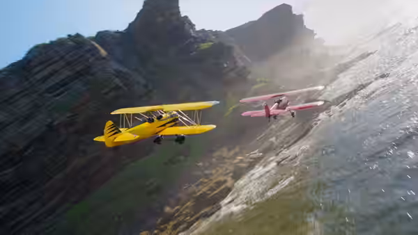Yellow and pink biplanes flying above rocky cliffs near the sea