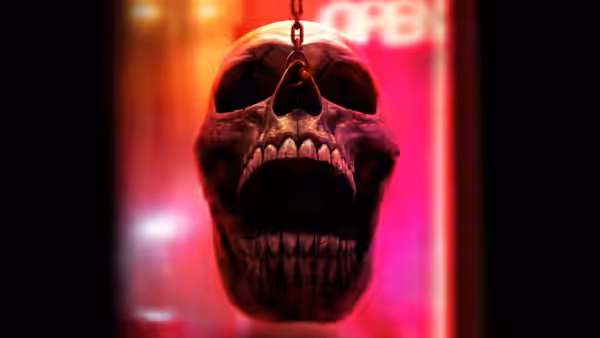 a skull hanging from a chain in front of a neon open sign