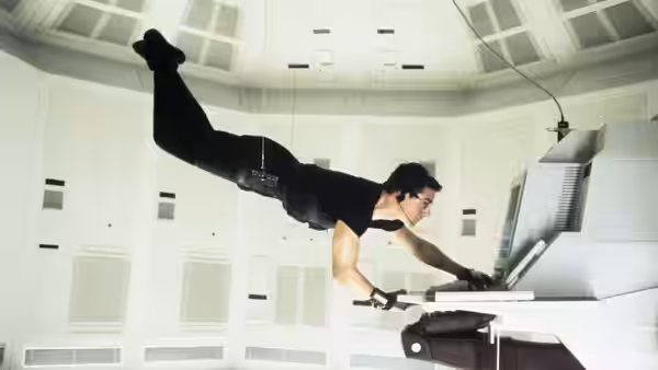 Ethan Hunt (Tom Cruise) suspended from cables accessing a computer terminal in a white room