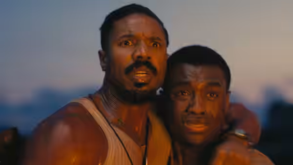 Michael B. Jordan and Miles Caton as Sammie Moore in a close embrace at dusk