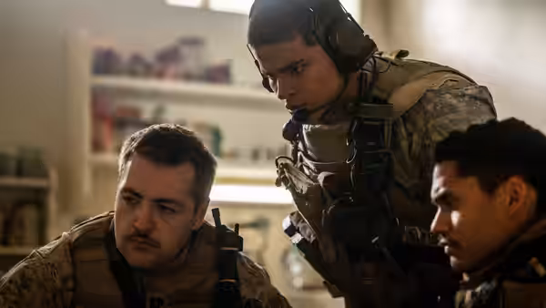 Three soldiers inside a room with shelves one kneeling and two standing