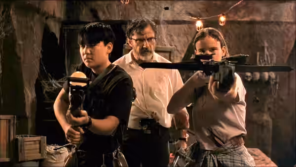 Kate Fuller (Juliette Lewis) aiming a crossbow with Jacob and Scott Fuller