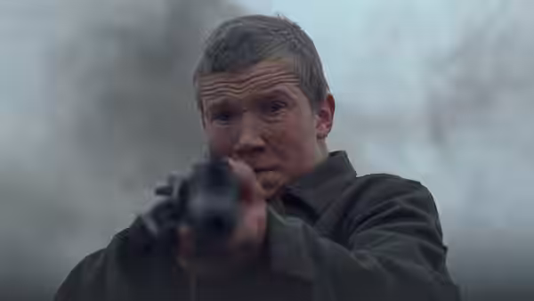 Flyora (Aleksei Kravchenko) aiming a pistol with a determined expression