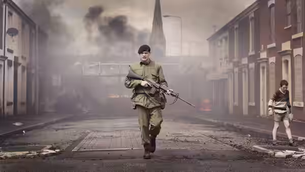 Gary Hook (Jack O'Connell) runs down a smoky street carrying a rifle