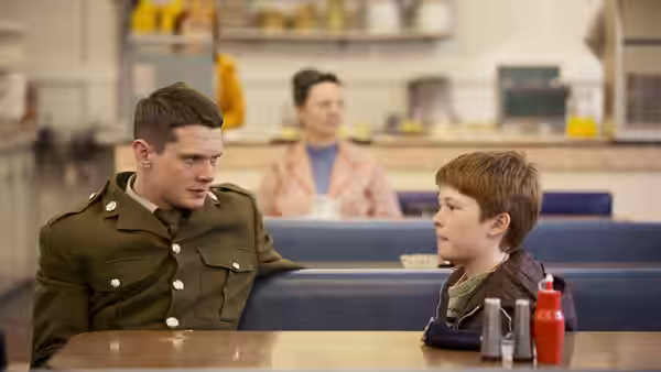 Gary Hook (Jack O'Connell) sits with a boy in a cafe booth