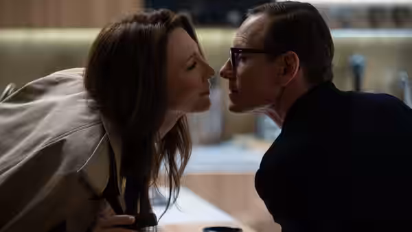 Woman and man with glasses leaning close facing each other