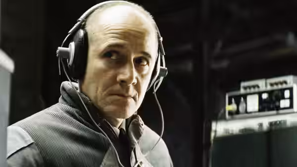 Gerd Wiesler (Ulrich Mühe) listening through headphones in a surveillance room