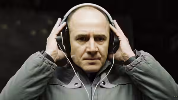 Gerd Wiesler (Ulrich Mühe) adjusting headphones with both hands