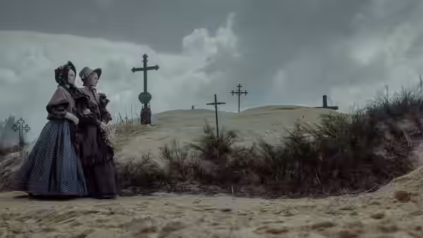Two women in period dresses standing among crosses on sandy ground