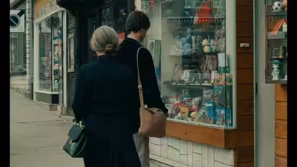 Yvon Targe (Christian Patey) and an older woman pause outside a shop window