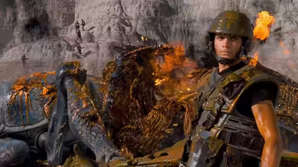 Johnny Rico (Casper Van Dien) beside a burning alien carcass in a cave