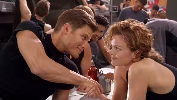 Johnny Rico (Casper Van Dien) and Dizzy Flores (Dina Meyer) holding hands across a table