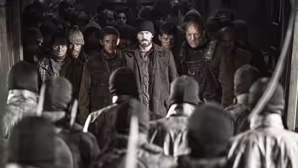Curtis (Chris Evans) leads a group of men down a crowded passage