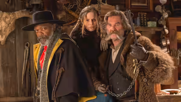 Major Marquis Warren, Daisy Domergue and John Ruth stand together in a dim room