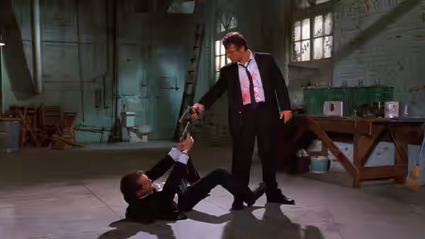 Mr. White (Harvey Keitel) standing over Mr. Orange (Tim Roth) on a warehouse floor