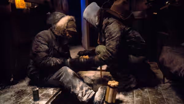 two men in winter parkas sitting on the floor playing chess