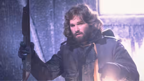 MacReady (Kurt Russell) gripping a rifle in a snowy icy setting