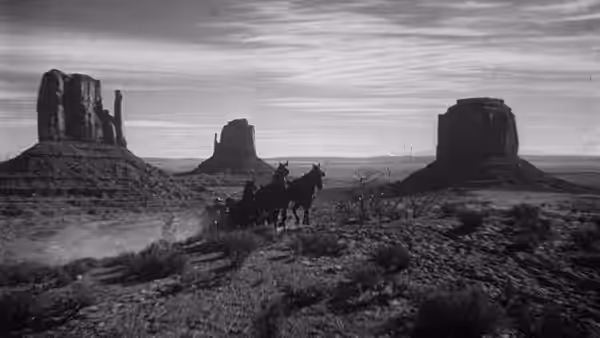 Stagecoach crosses desert plain with distant rock formations
