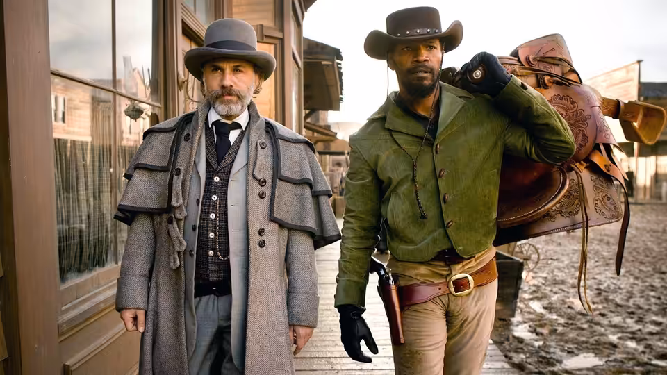 Dr. King Schultz (Christoph Waltz) and Django (Jamie Foxx) standing outside a wooden building
