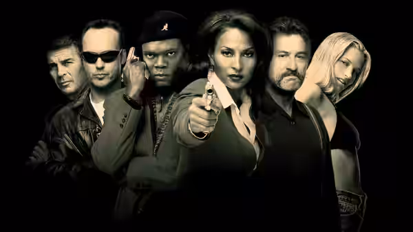 Jackie Brown (Pam Grier) aiming a pistol forward with cast members behind