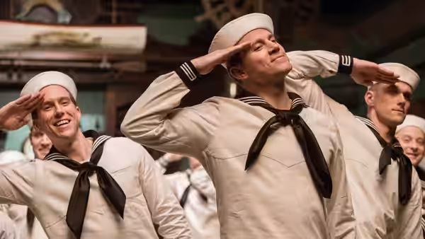 Burt Gurney (Channing Tatum) and sailors in white uniforms salute on deck