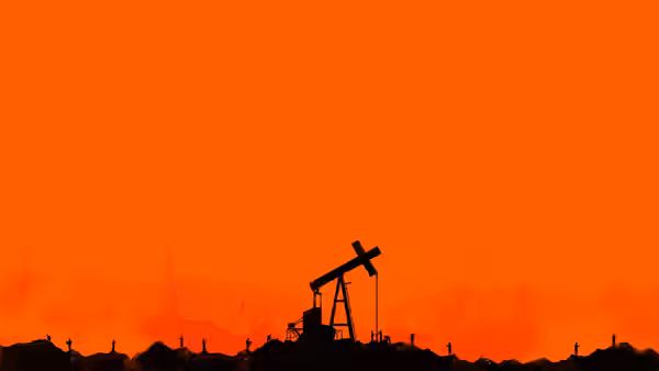 Silhouette of oil pump jack against bright orange sky at dusk