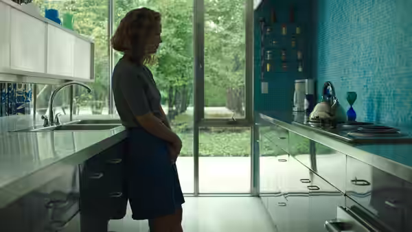 Casey (Haley Lu Richardson) standing alone in a modern kitchen