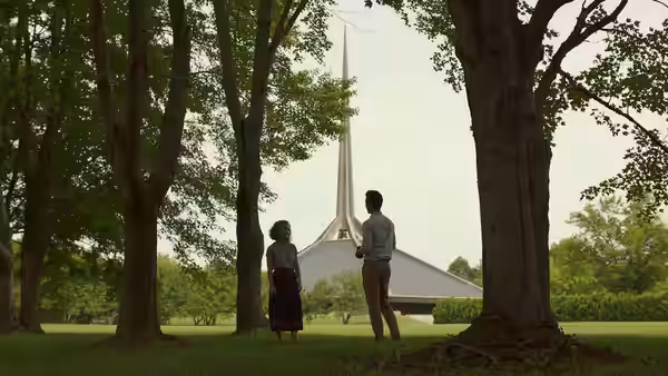 Casey (Haley Lu Richardson) and Jin (John Cho) standing among trees near a building