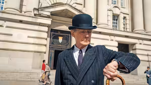 Williams (Bill Nighy) checks his watch outside a grand office building