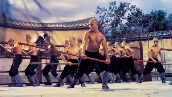 Shaolin trainees practice staff techniques in formation in a temple courtyard