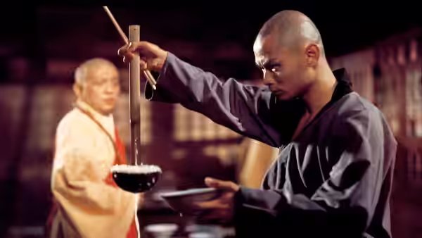 Liu Yu-de (Gordon Liu) ladles food into a bowl as a monk watches