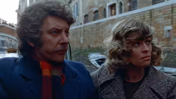 John Baxter (Donald Sutherland) and Laura Baxter (Julie Christie) stand together by a canal