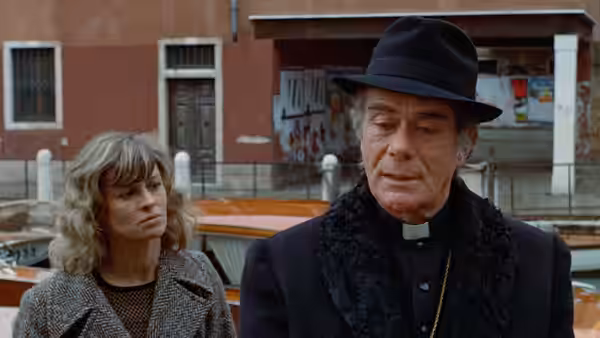 Laura Baxter (Julie Christie) stands with Bishop Barbarrigo (Massimo Serato) near a canal