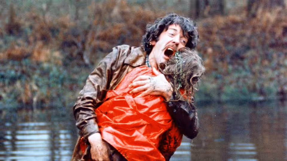 John Baxter (Donald Sutherland) carries a body in a red coat from the water