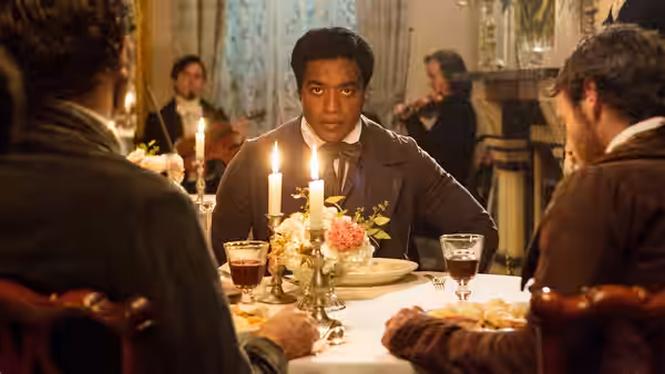 Solomon Northup (Chiwetel Ejiofor) sits at the head of a candlelit dinner table
