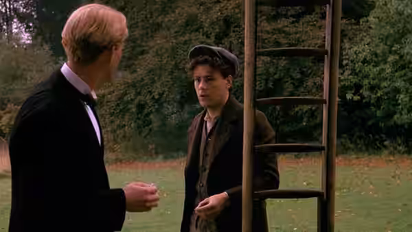 Clive Durham (Hugh Grant) faces Alec Scudder (Rupert Graves) beside a garden ladder