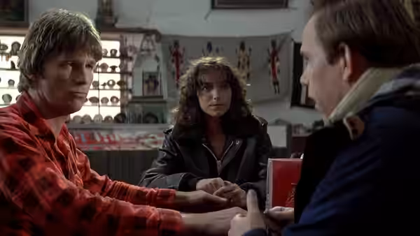 Starman (Jeff Bridges) and Jenny (Karen Allen) sit across from a man in a diner