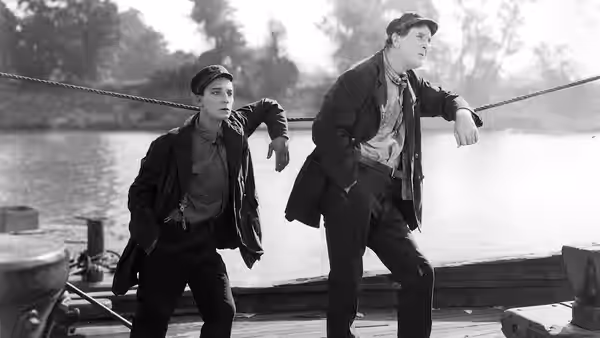 Steamboat Bill Jr. (Buster Keaton) and Kitty King (Marion Byron) hurry across a boat deck