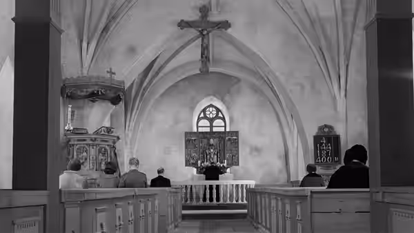 Churchgoers sit facing the altar beneath a large crucifix
