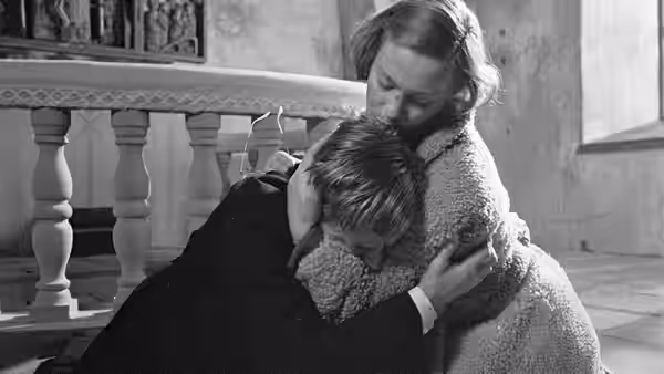 Märta Lundberg (Ingrid Thulin) embraces Tomas Ericsson (Gunnar Björnstrand) beside the church pews