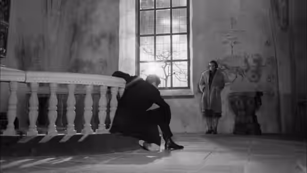 Tomas Ericsson sits by the church railing as Märta Lundberg stands near the window