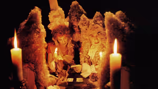 A gathering of figures in ornate wigs examines documents by candlelight at a table