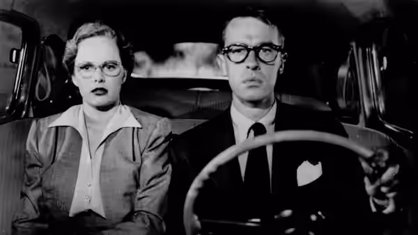 Annie Laurie Starr (Peggy Cummins) rides beside Bart Tare (John Dall) as he drives