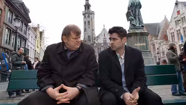 Ken (Brendan Gleeson) and Ray (Colin Farrell) seated on a bench in a square