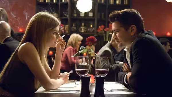 Chloë (Clémence Poésy) and Ray (Colin Farrell) at a table with wine glasses