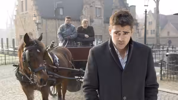 Ray (Colin Farrell) standing before a horse-drawn carriage in a square