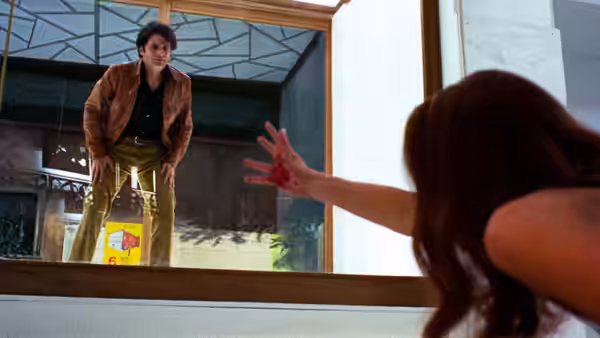 Sam Dalmas (Tony Musante) stands in a doorway as a woman reaches toward him