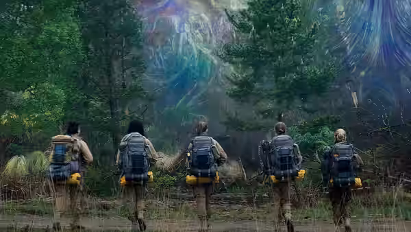 Five expedition members walk toward a shimmering iridescent wall in woodland