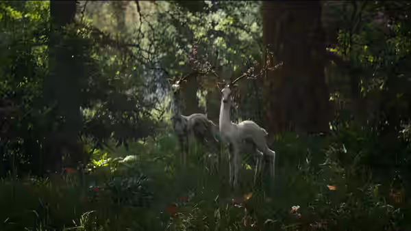 Two white deer with colorful antlers stand in a sunlit forest clearing