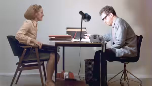 Marianne (Liv Ullmann) and Johan (Erland Josephson) talk across an office desk